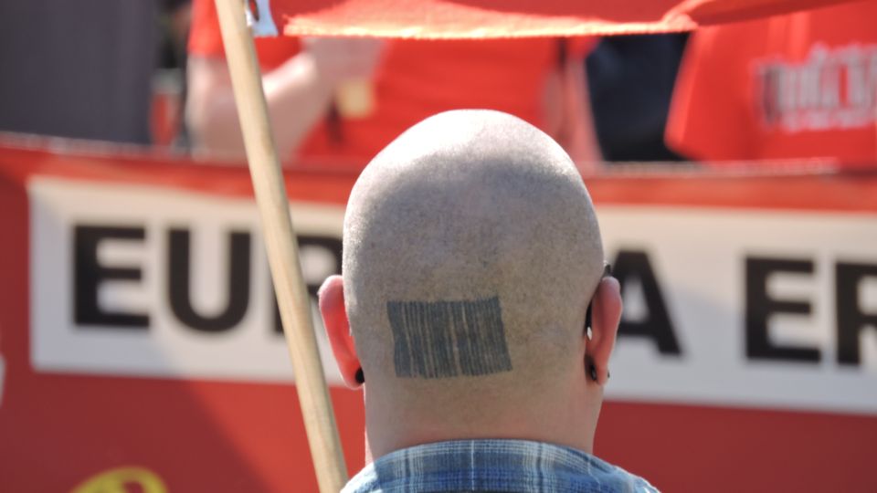 Symbolbilf: Nazi bei einer rechten Demo. Ein Glatzkopf von hinten.
