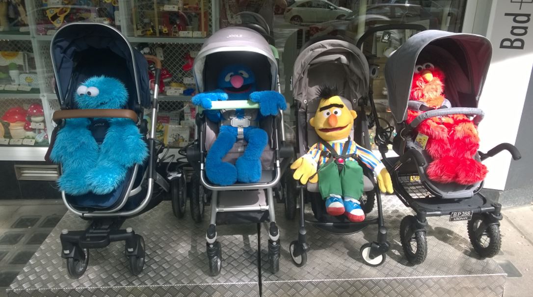 Vier Figuren der Sesamstraße in Kinderwagen. Darunter Bert und Grobi.